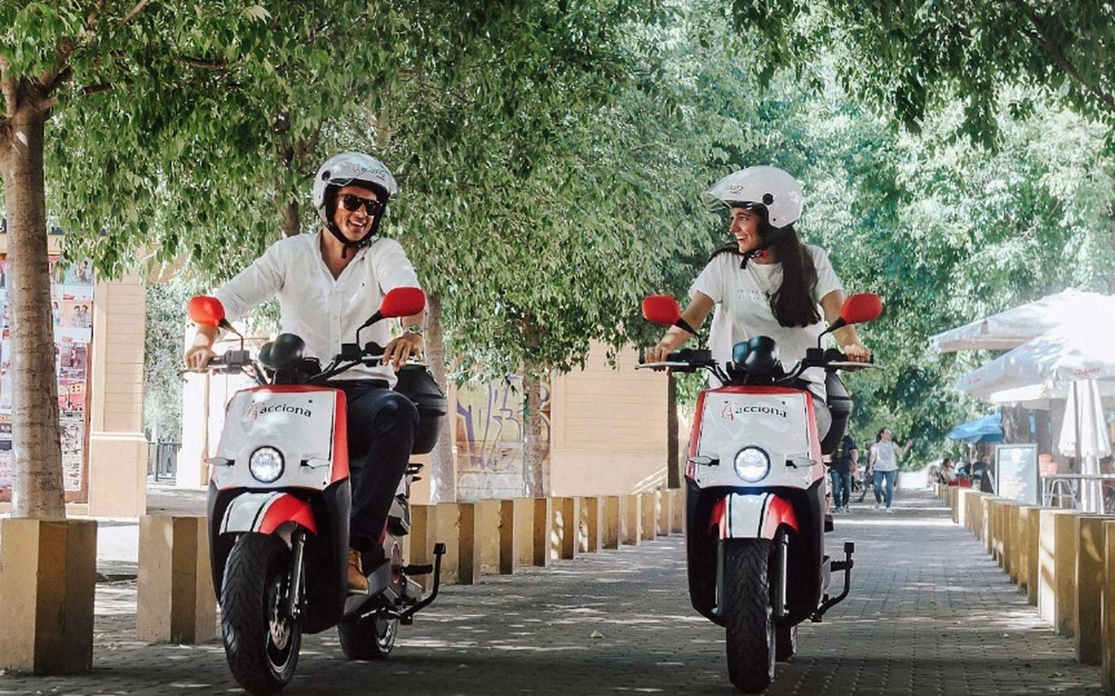 Dos usuarios de las motos eléctricas de alquiler en la Alameda.