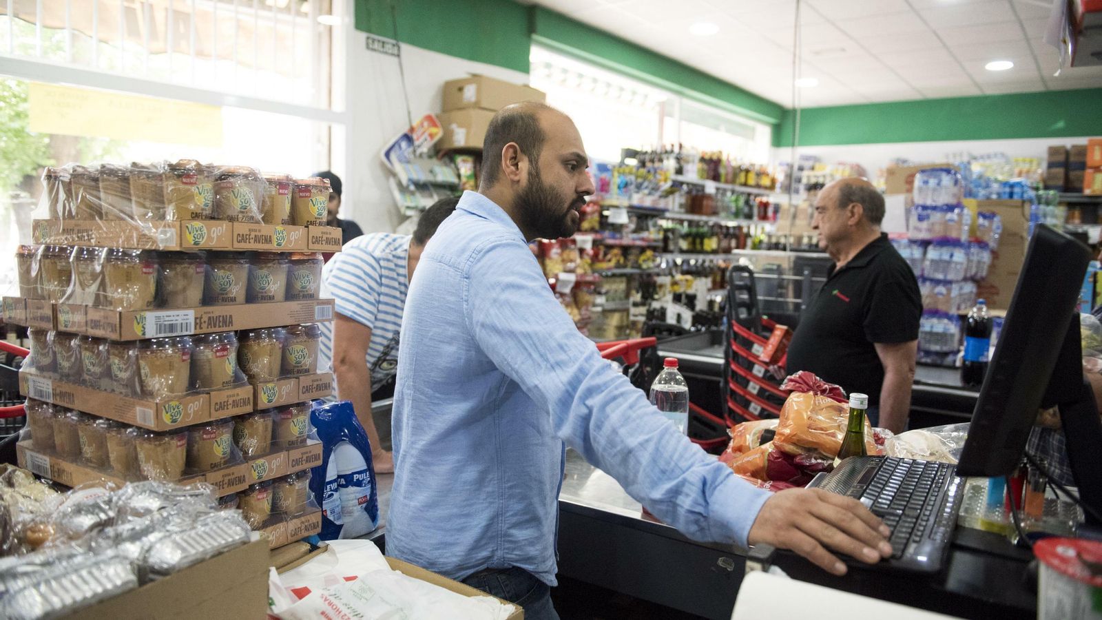 Ahmed atiende a los clientes en el Covirán que lleva el nombre de su hermano Ali
