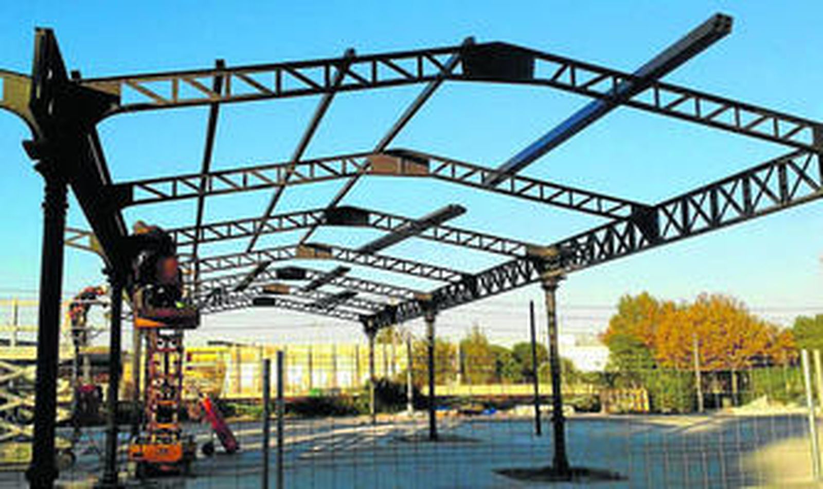 Operarios trabajan en la instalación de la marquesina que será cubierta para dar sombra.