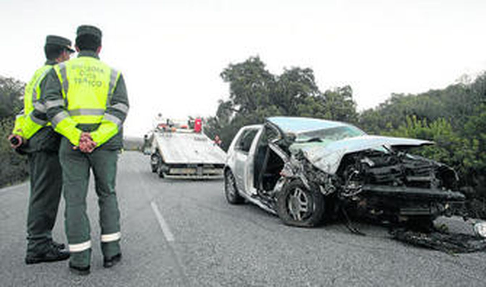 Una pareja de la Guardia Civil de Tráfico observa el estado en que quedó el Volkswagen Golf accidentado ayer en la C-440.