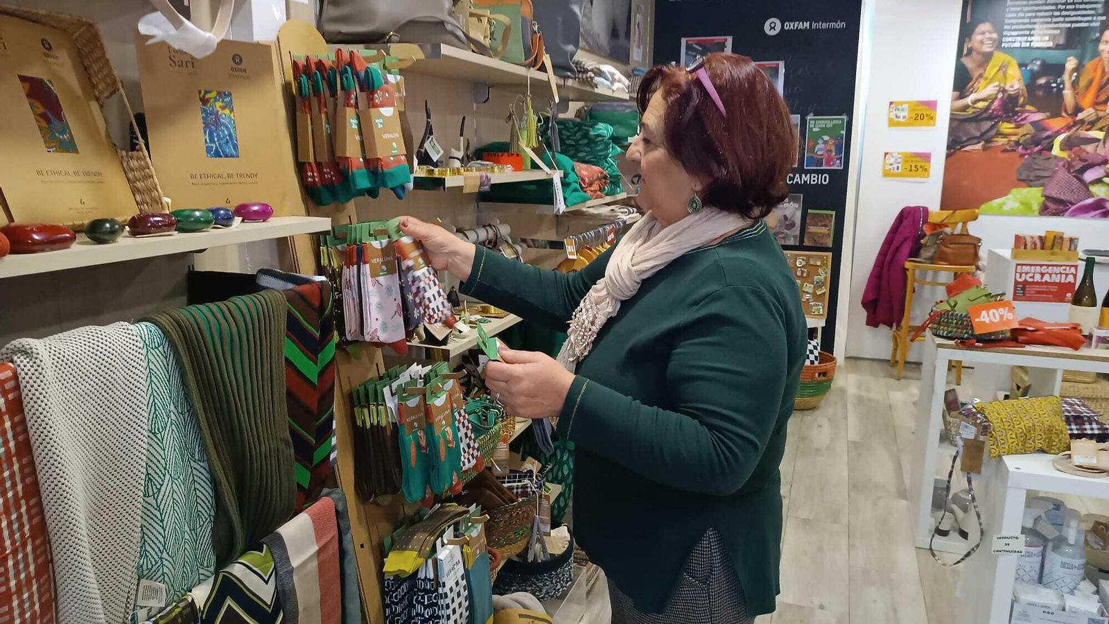 María reponiendo artículos en la tienda.