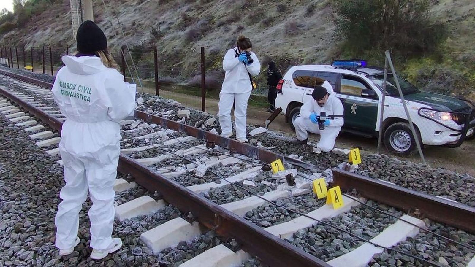 Guardias civiles fotografían el trozo de vía rota.