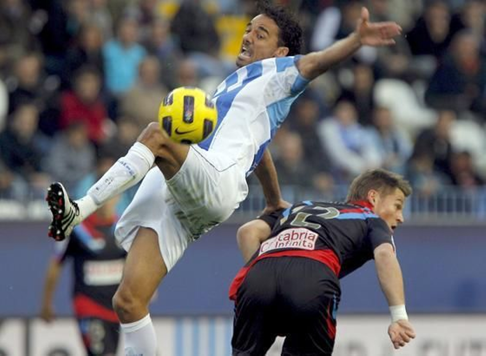 El defensa del Málaga Weligton salta para conseguir el control del balón ante el delantero del Racing Markus Rosenberg.

Foto: Jorge Zapata/EFE