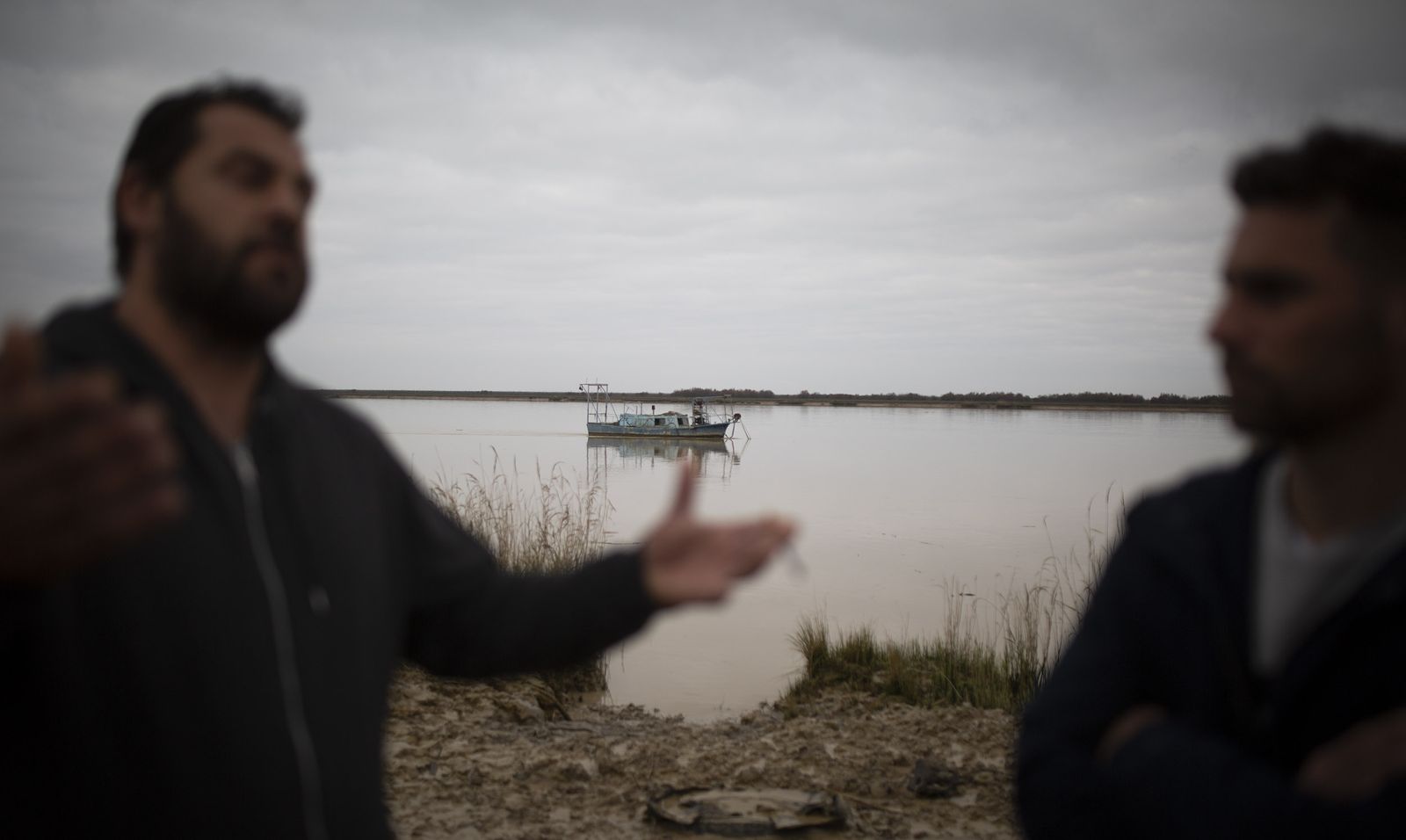 Dos representantes de la asociación Treleis, con un barco angulero de fondo.