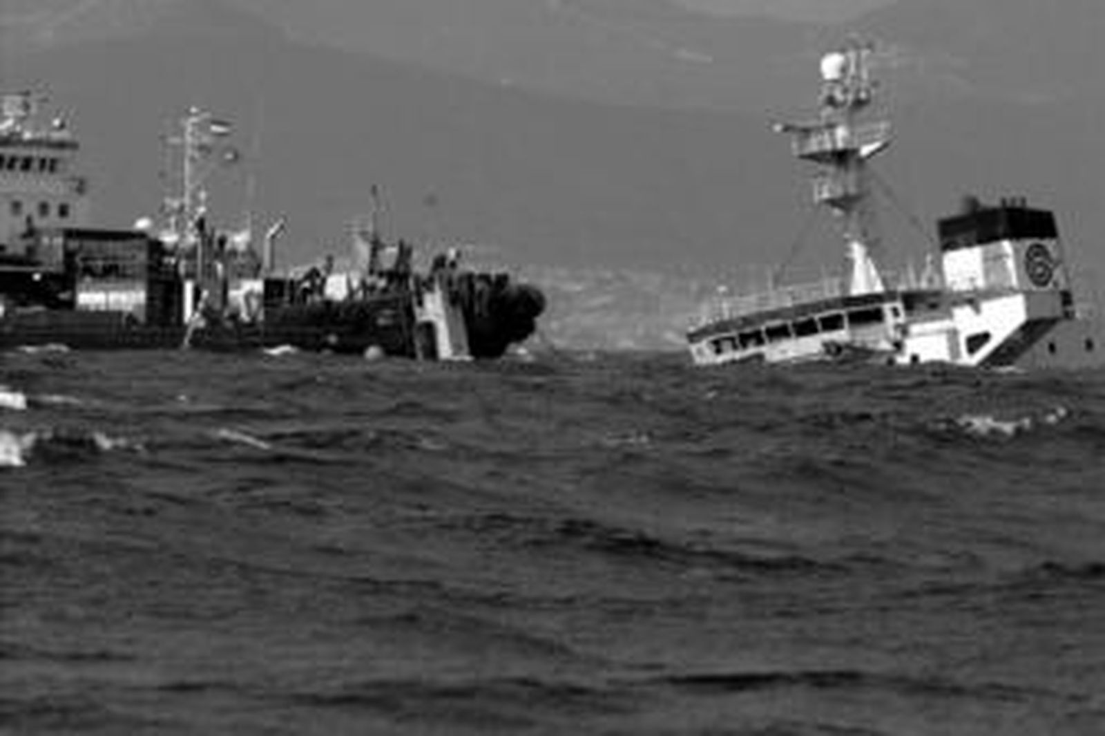 Uno de los barcos de la empresa encargada del rescate trabaja junto a la única parte que queda a flote del 'New Flame'.