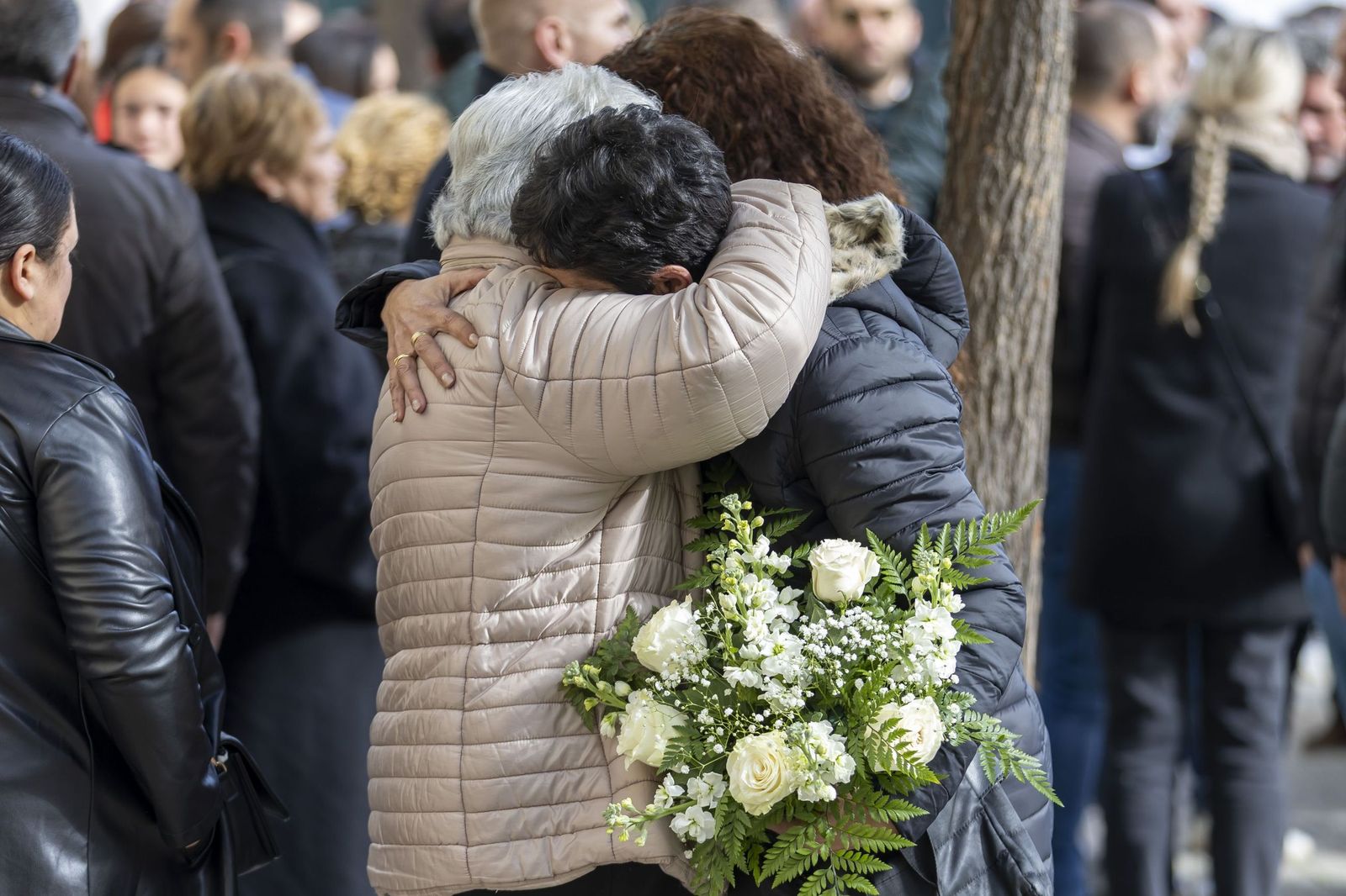 Dos personas se abrazan en el funeral de una de las víctimas de Adamuz.
