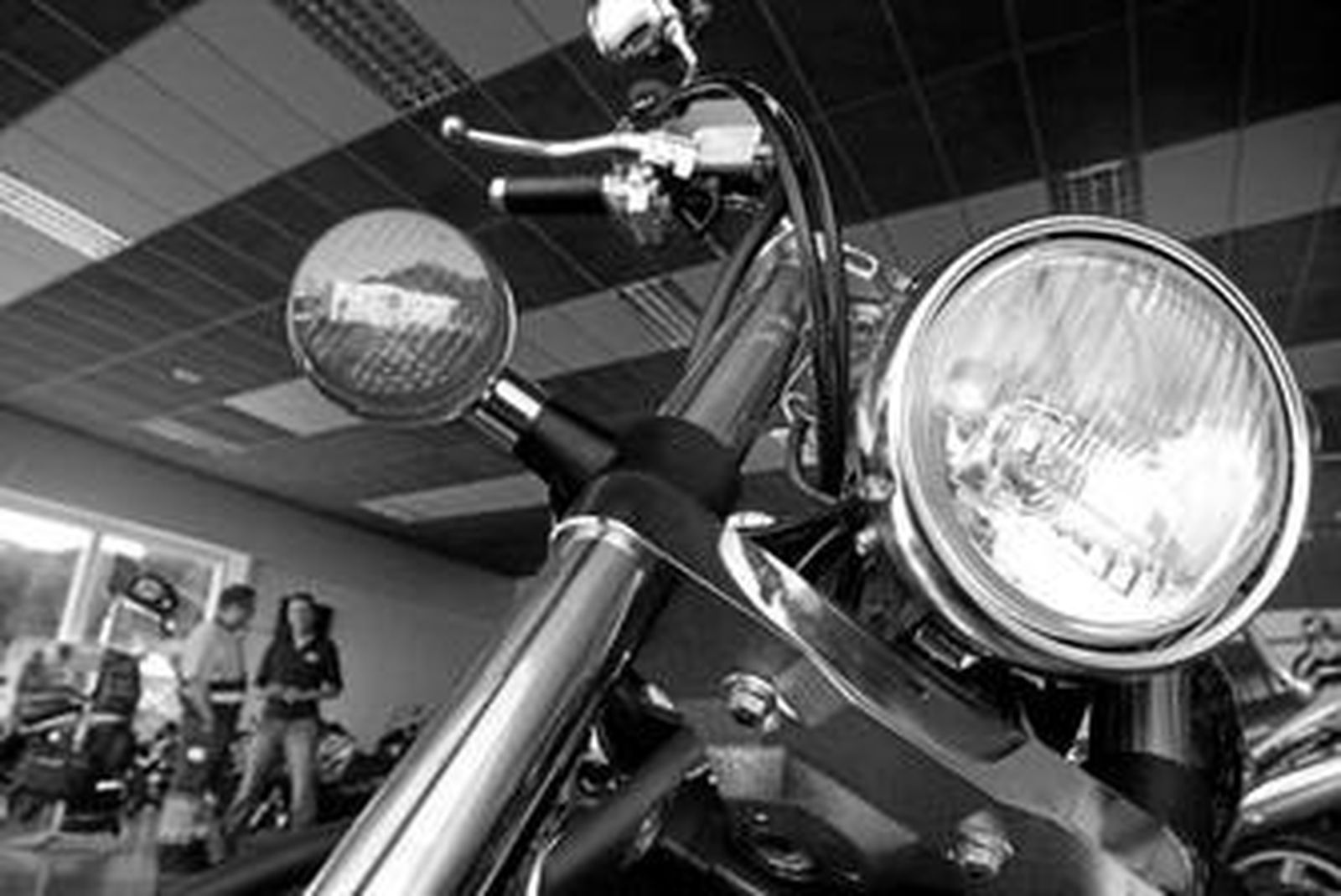 Una moto en primer plano y al fondo un comercial de Moto Algeciras con un cliente.