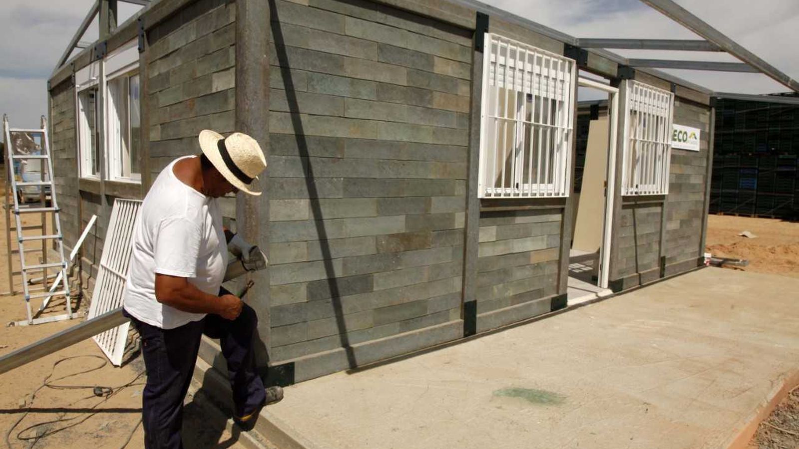 Un operario realiza labores de la edificación de plástico reciclado.