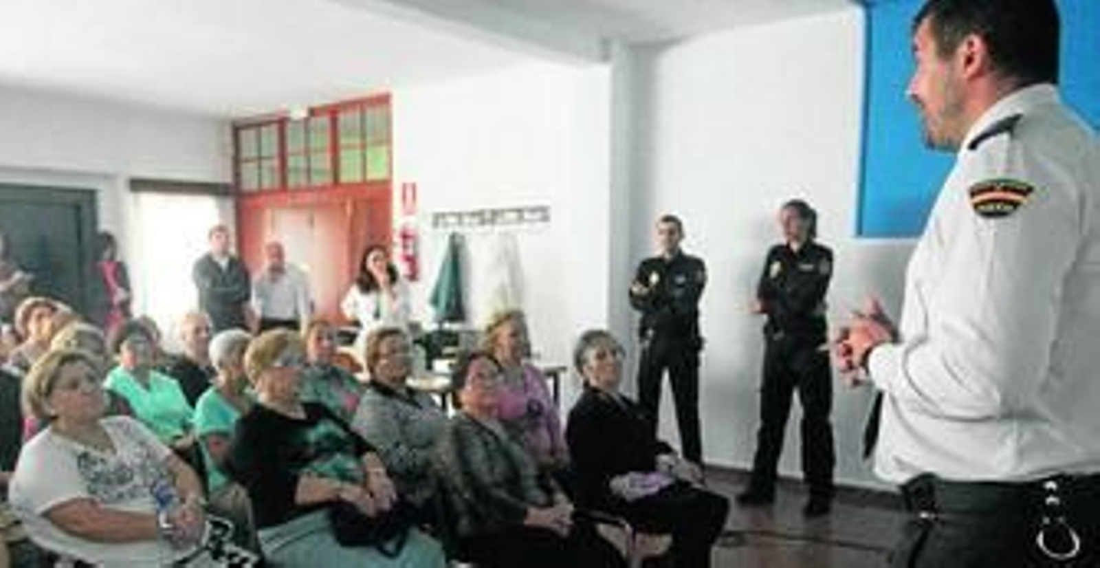 Uno de los agentes explica a los mayores de Padre Pandelo cómo prevenir robos y timos.