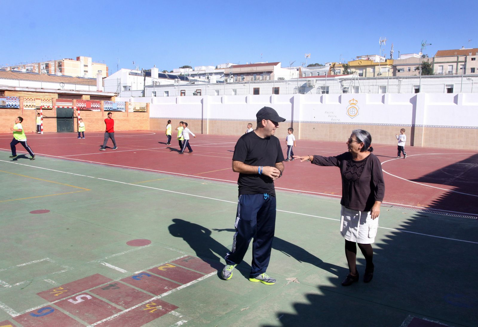 Docentes y niños en las pistas deportivas del Colegio Virgen de Belén.