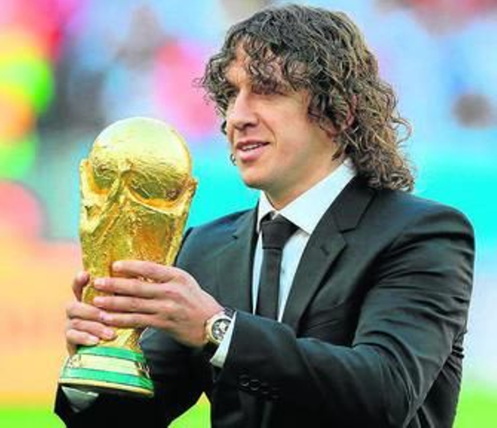 Puyol, ausente en Brasil 2014, portó el trofeo antes del inicio de la final.