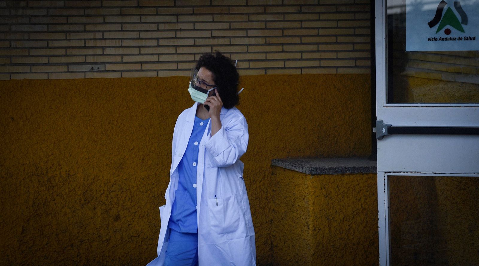 Una profesional sanitaria habla por teléfono a las puertas de un centro hospitalario de la capital.