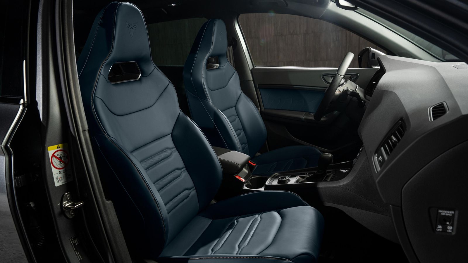 Los asientos, con reposacabezas integrados siempre, pueden estar tapizados en piel, bien de color negro, bien azul.