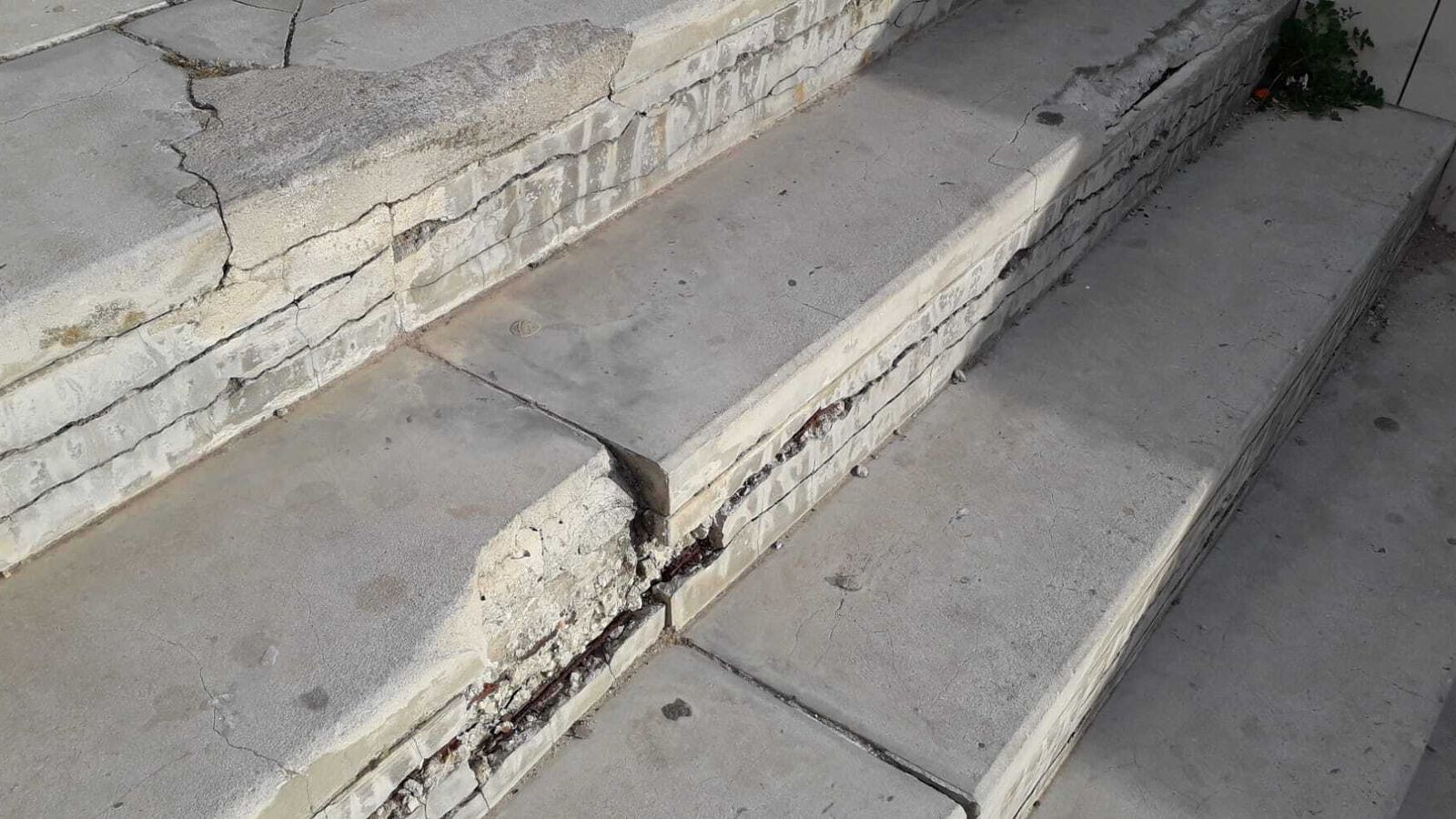 Escalón con el canto completamente mordido en la escalera de acceso.