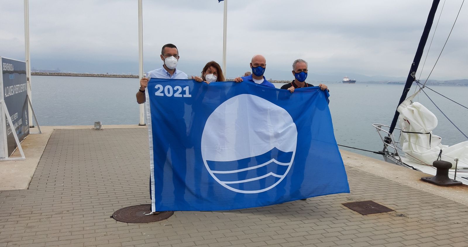 Los responsables municipales y de Marina Alcaidesa muestran la bandera azul.