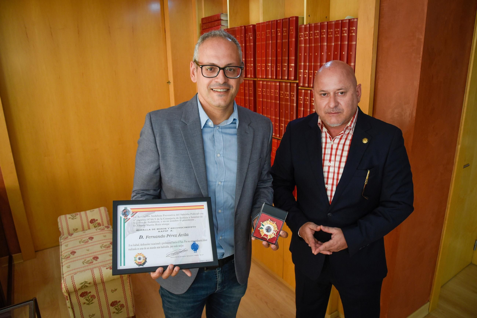 El periodista Fernando Pérez Ávila posa con la medalla y un diploma, junto al presidente de la Asociación Preventiva del Suicidio Policial, Alberto Martín.
