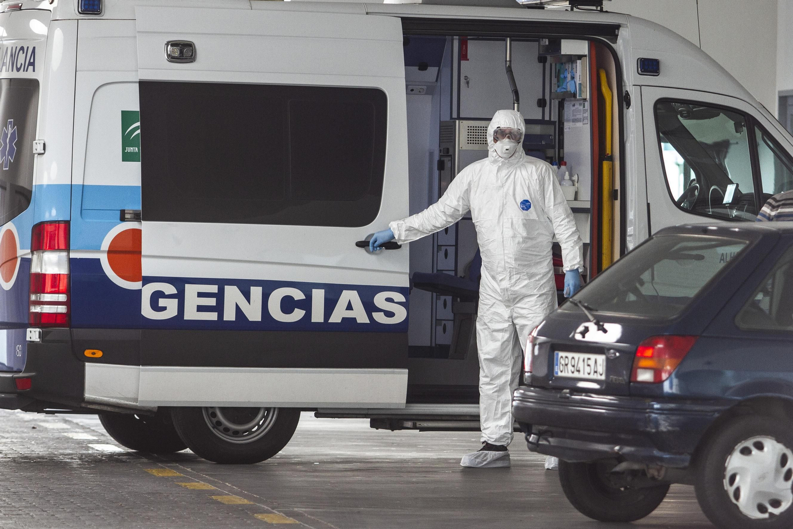 Un sanitario, protegido, sale de una ambulancia en Granada.