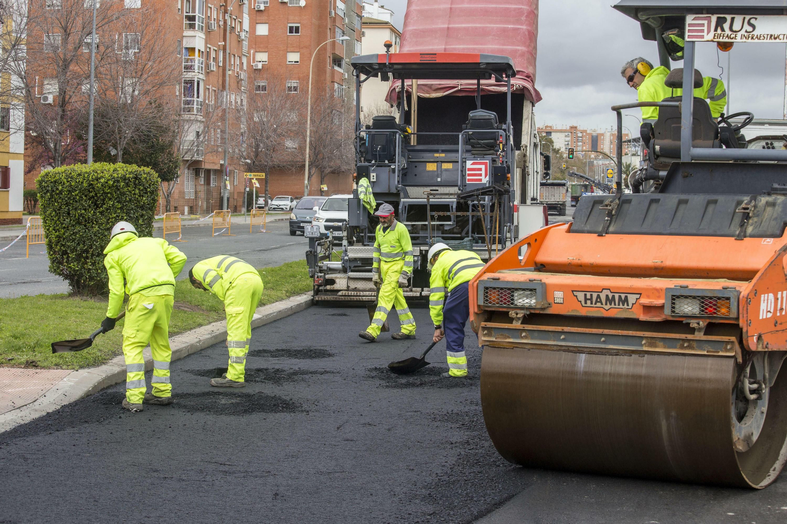 Operarios asfaltan una calle de la capital onubense.
