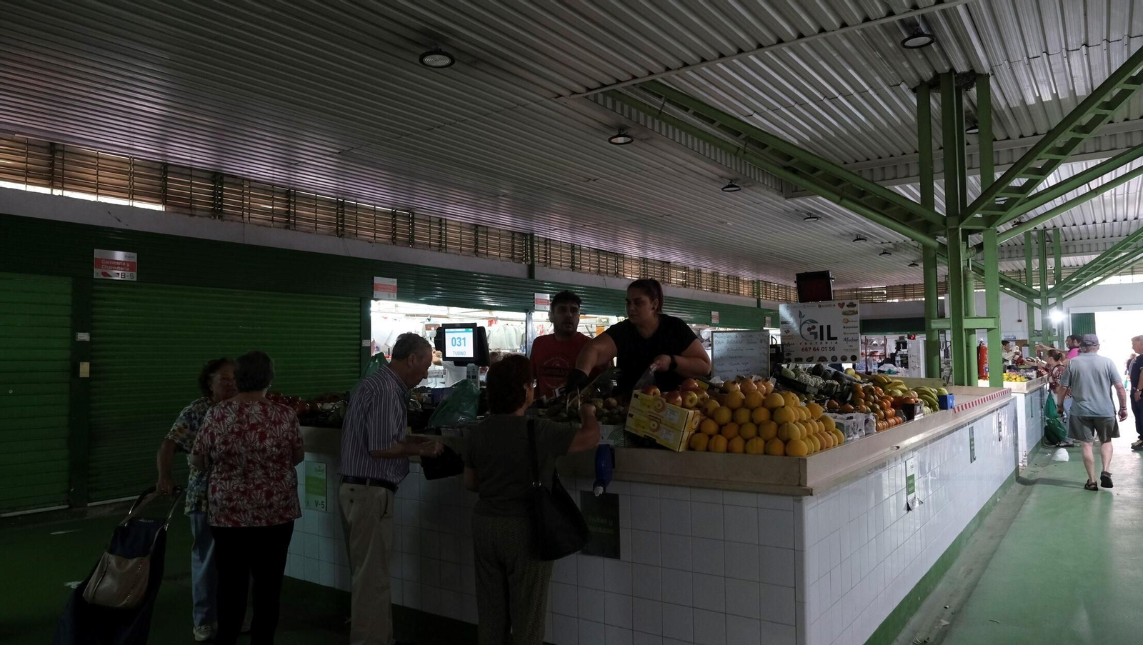 Uno de los puestos sin luz del Mercado de Los Ángeles. En el techo,  focos apagados.