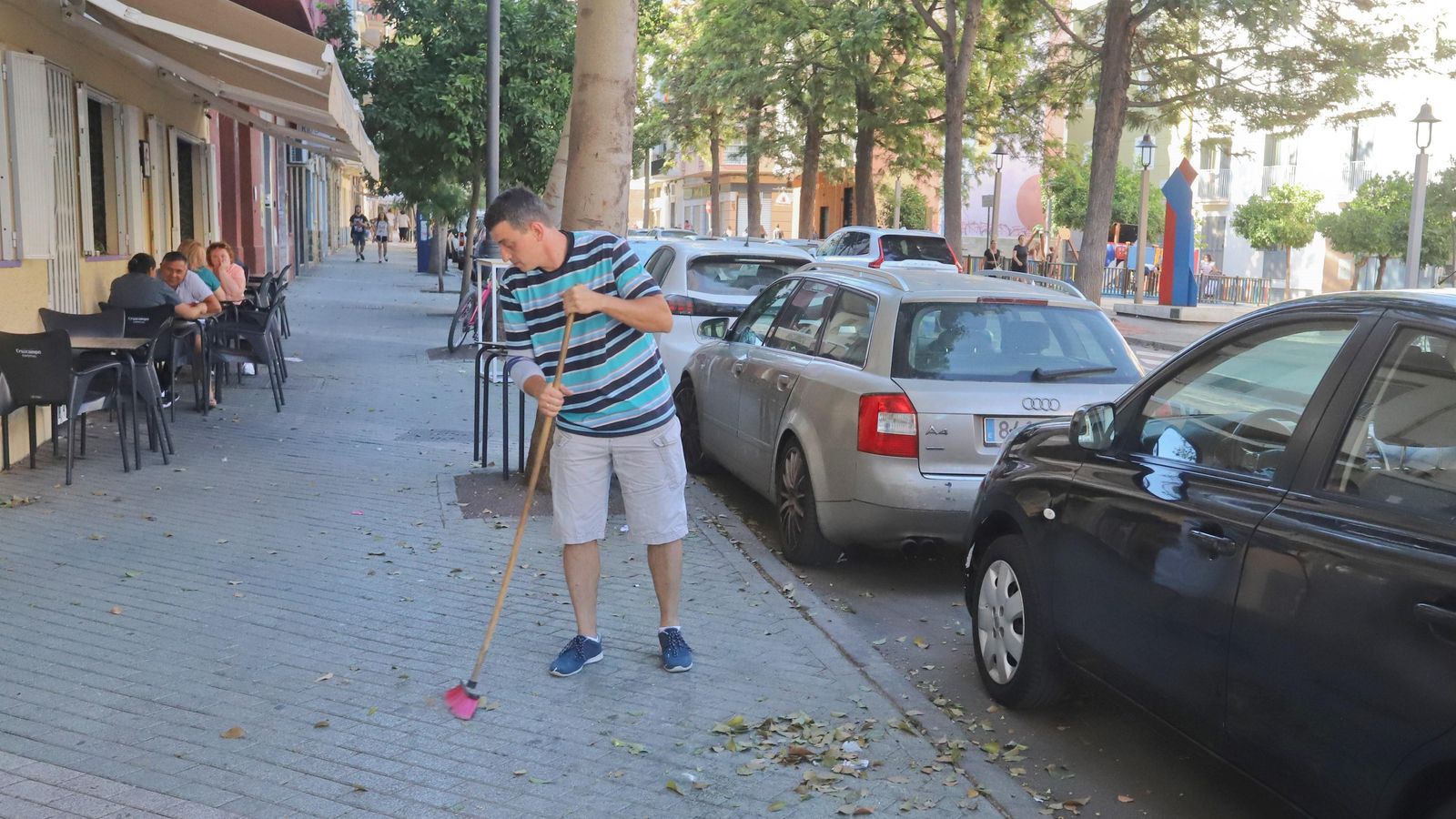 Un comerciante barre su acera en La Trinidad.