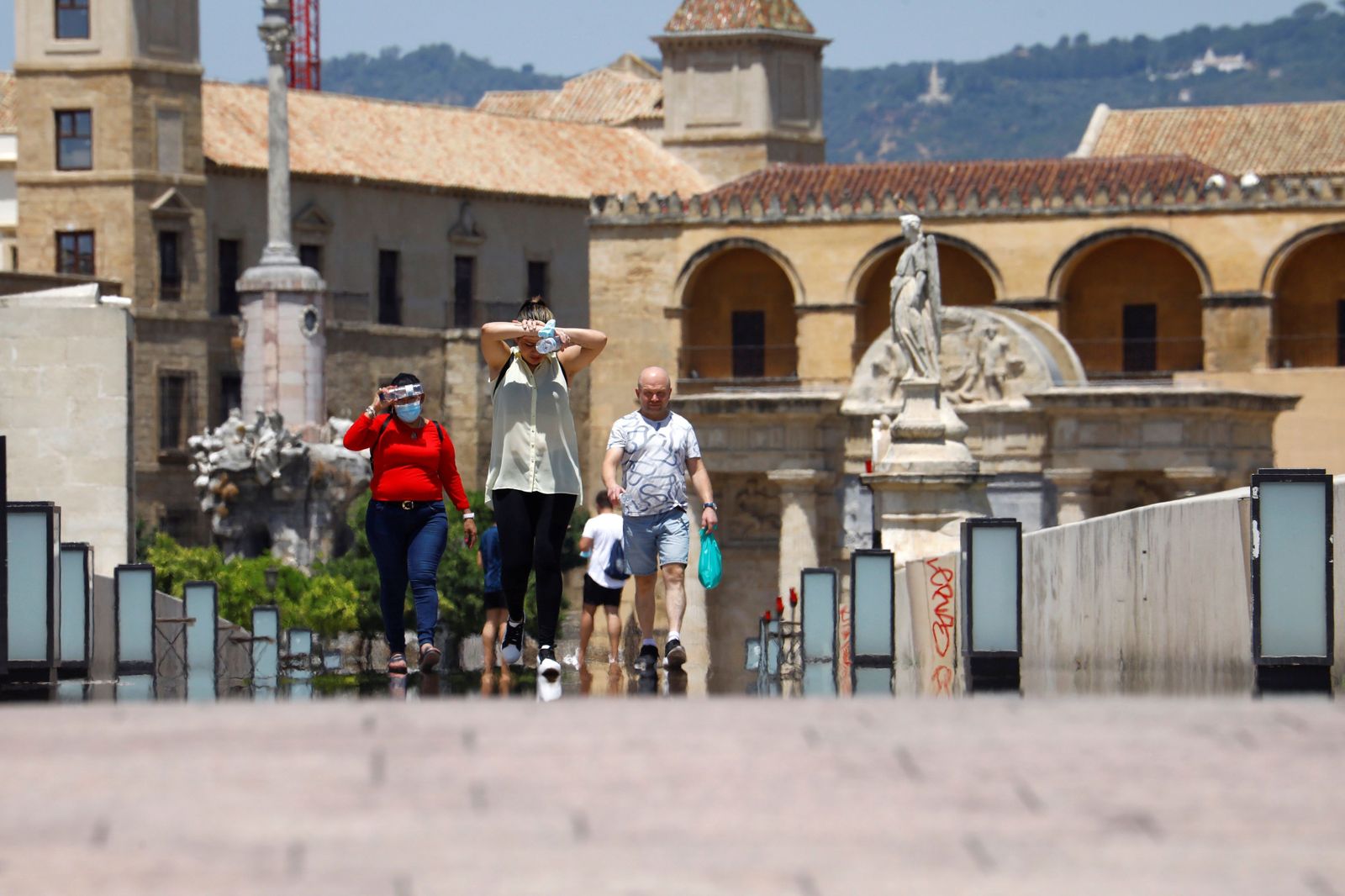 Varias personas caminan por el Puente Romano de Córdoba.