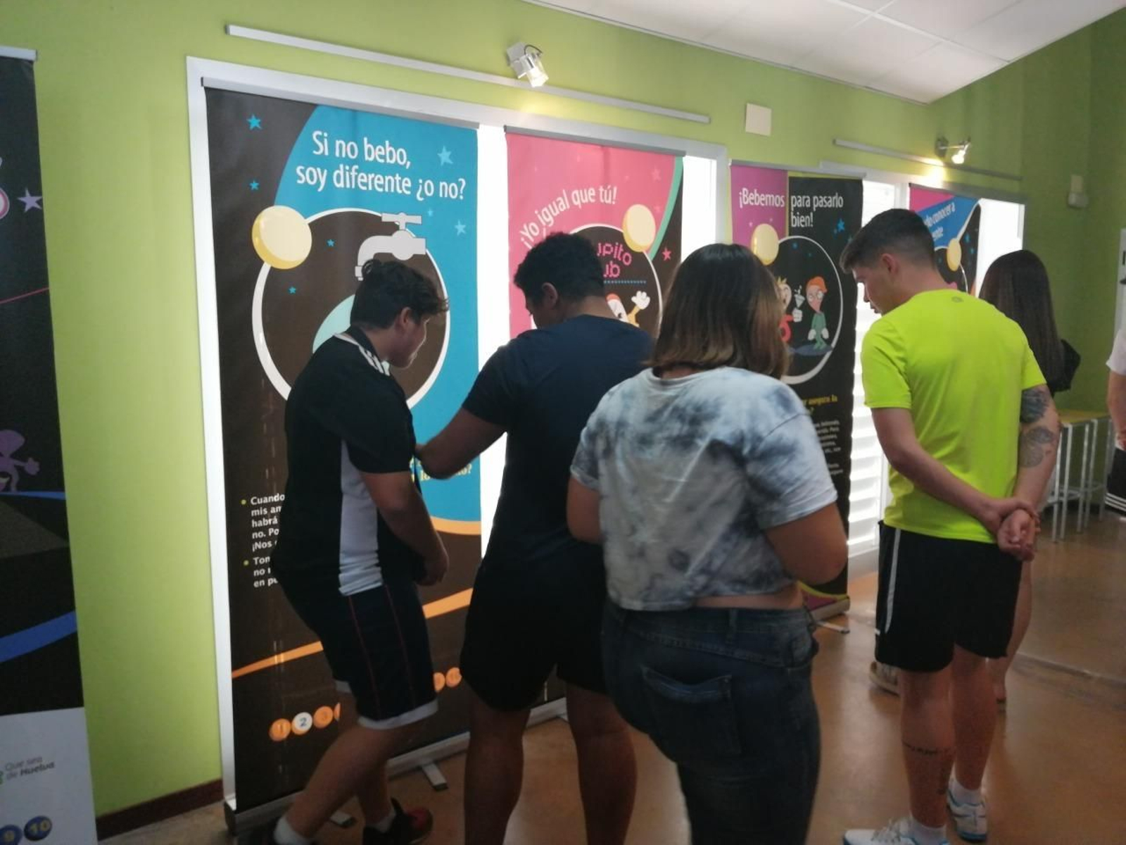 Jóvenes miran los paneles de la exposición 'Salimos'.