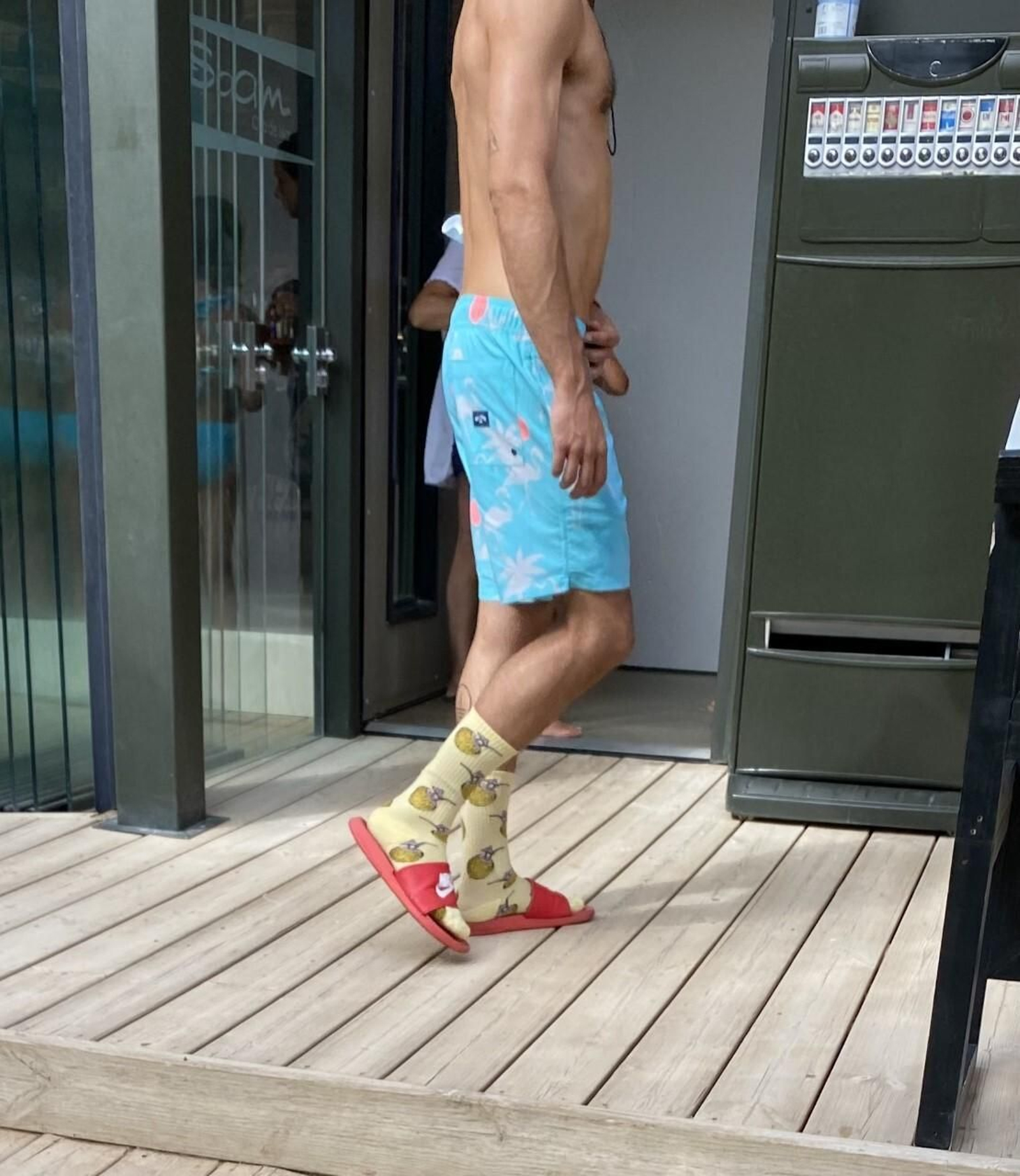 A pecho descubierto, con bañador, chanclas y calcetines. El horripilante modelo veraniego.