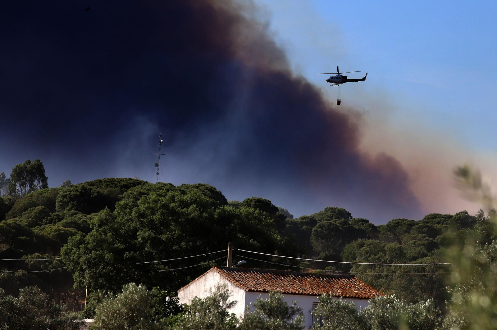 Un helicóptero descargando agua sobre el fuego de Fuente de la Corcha, en Beas, el sábado.
