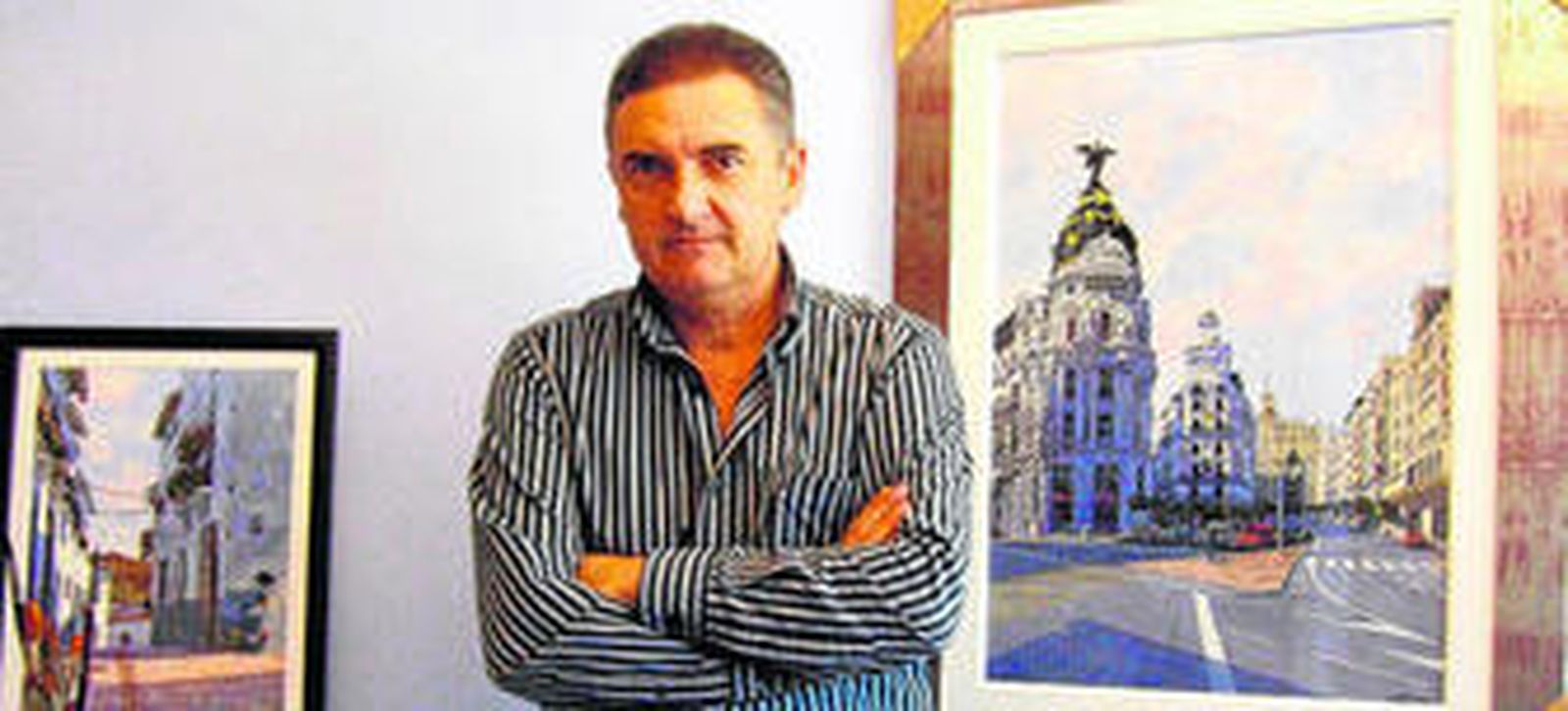 El acuarelista en su estudio con las obras que lo definen como artista.