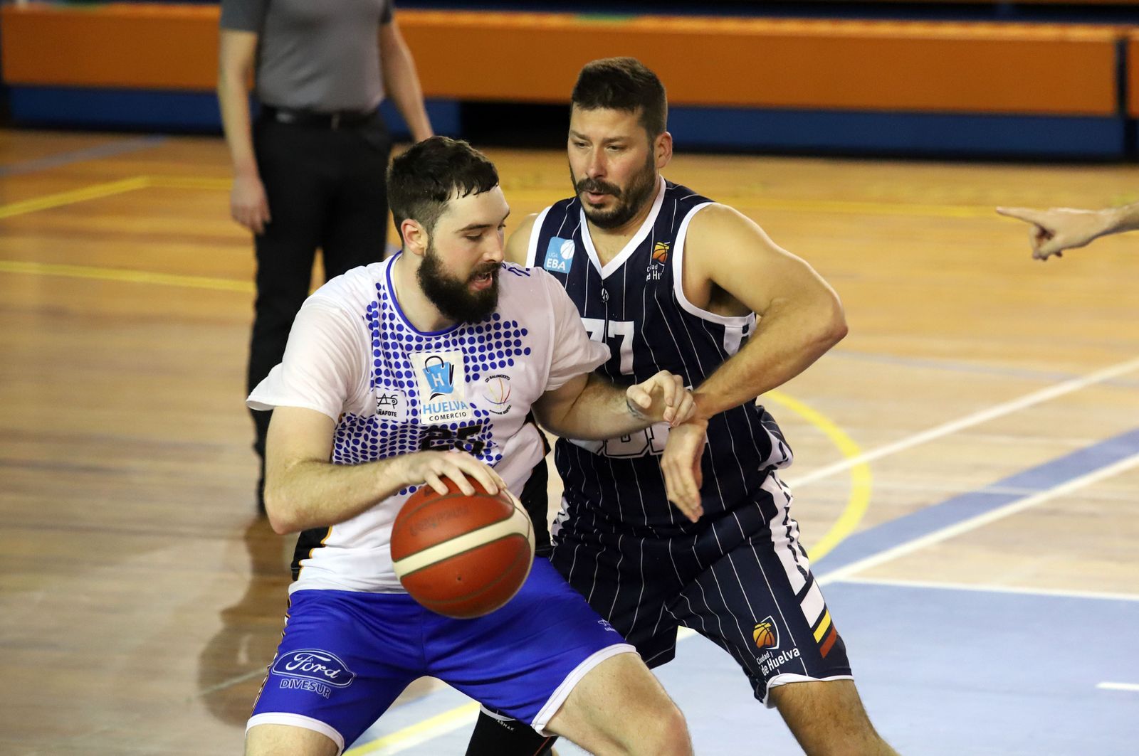 Germán Rodríguez defiende a un jugador del Huelva Comercio.
