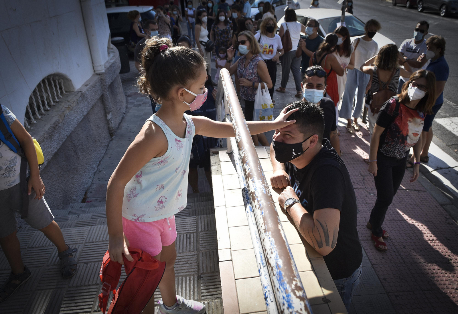 Una alumna se despida de su padre al entrar en el colegio.