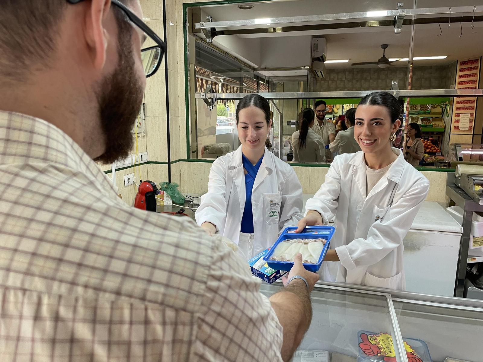 Profesionales sanitarios entregan alimentos de la cesta a un participante.