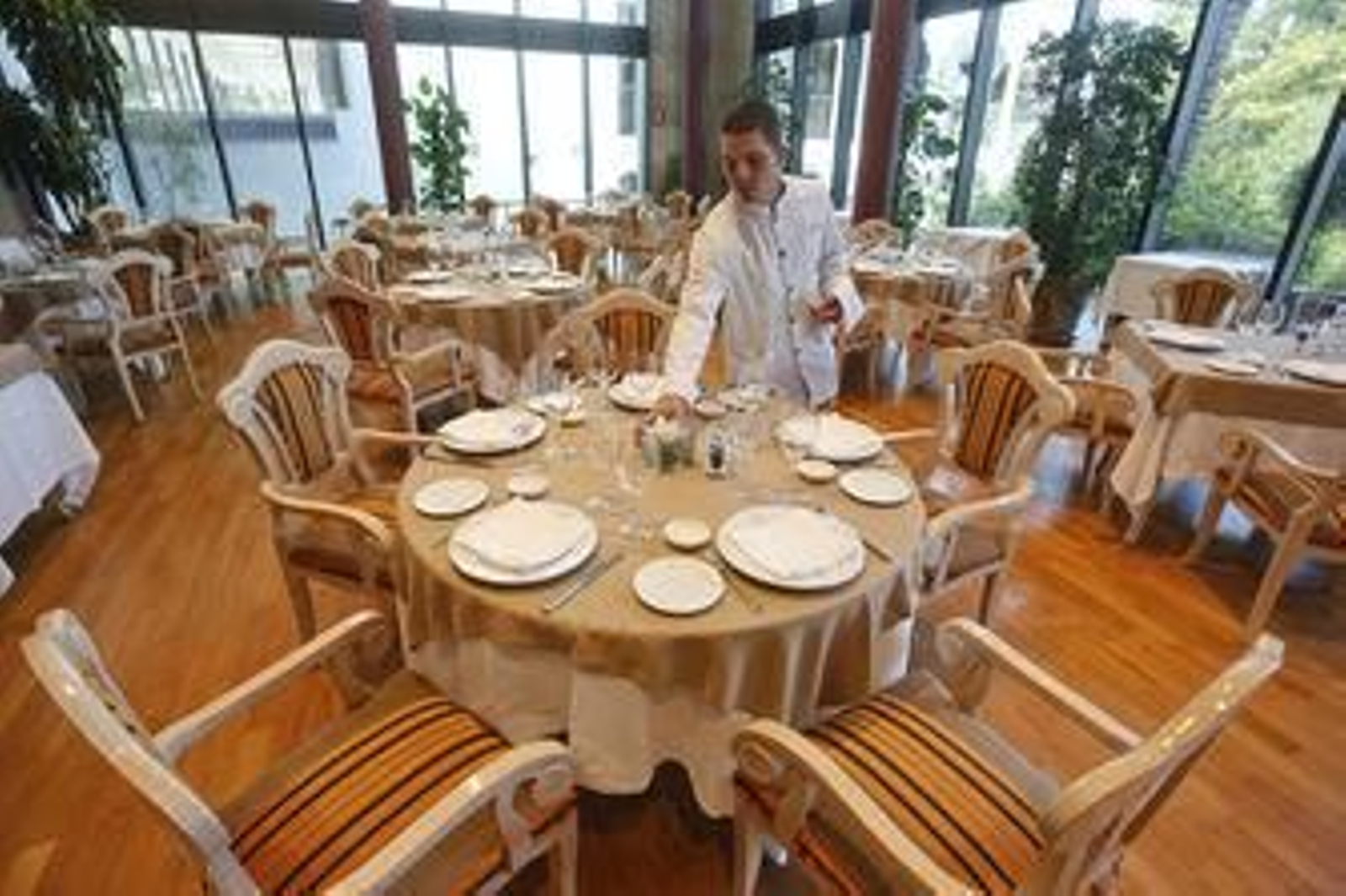 Un alumno de sala prepara una mesa del restaurante de La Cónsula.