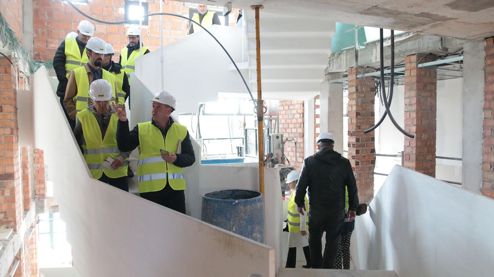 La comitiva, con presencia de la empresa constructora, Jarquil, desciende las nuevas escaleras