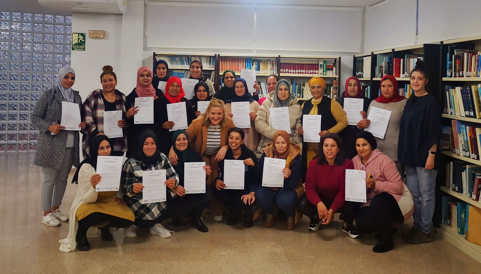 Alumnas con sus diplomas junto a profesoras del curso.
