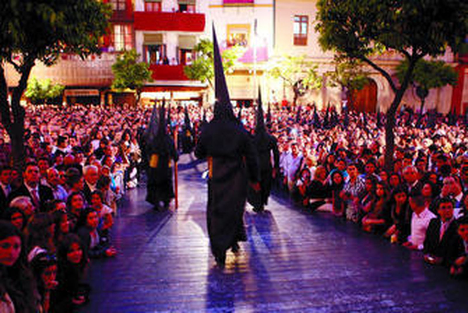 Nazarenos de negro bajan por la rampa del Salvador para cerrar el Domingo de Ramos.