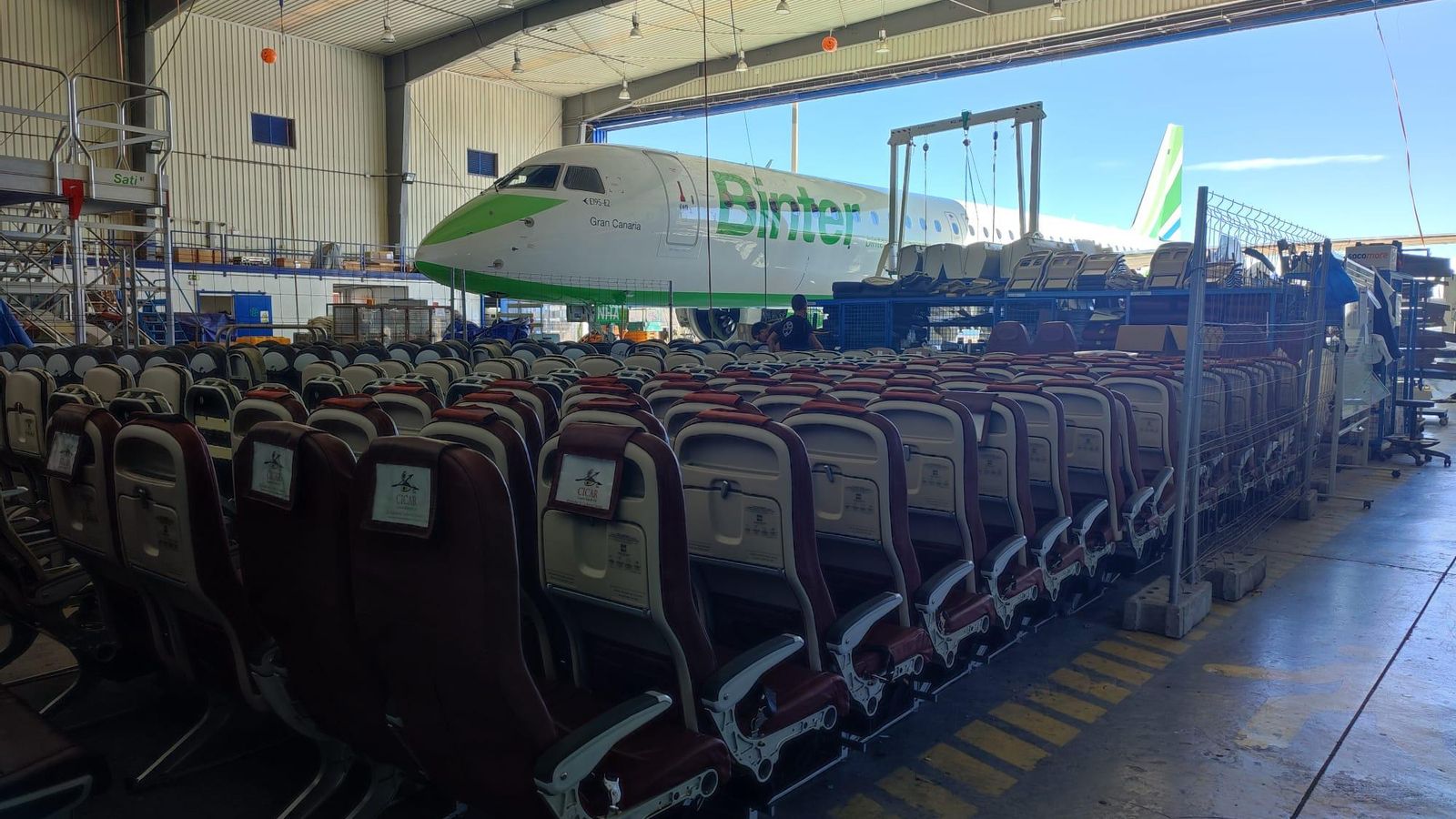 Asientos del Embraer, al fondo sobresaliendo fuera del hangar de Binter.