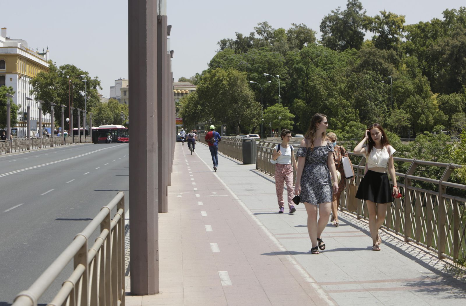Un grupo de personas mientras cruzan uno de los puentes de Sevilla.