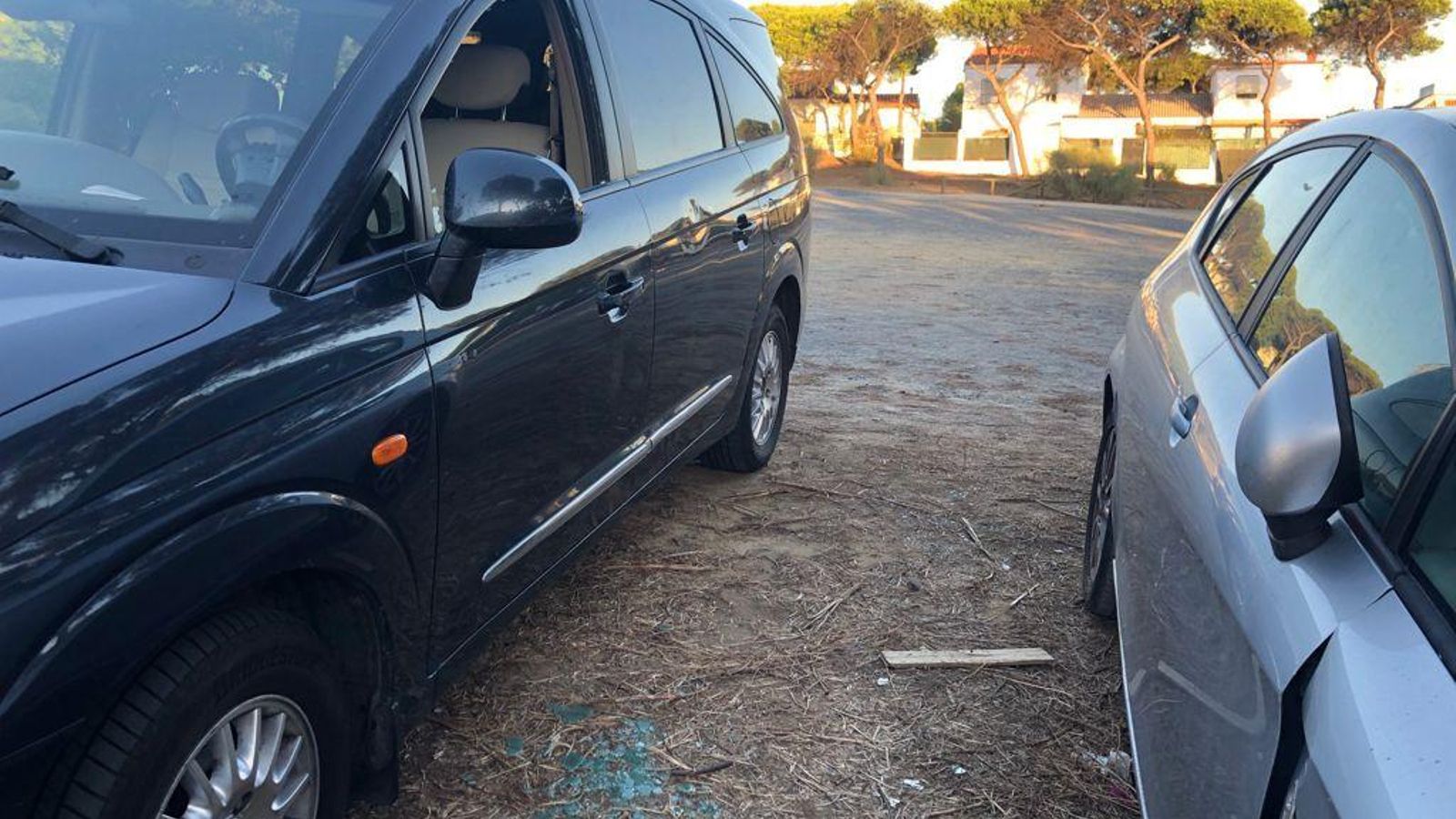 Otro vehículo con la luna rota y restos de cristales en el suelo, en el descampado regulado como Zona Roja ORA en Punta Umbría.