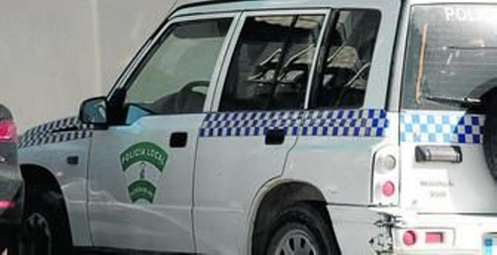 El patrullero de la Policía Local de Alcolea del Río, aparcado en los juzgados de Lora.