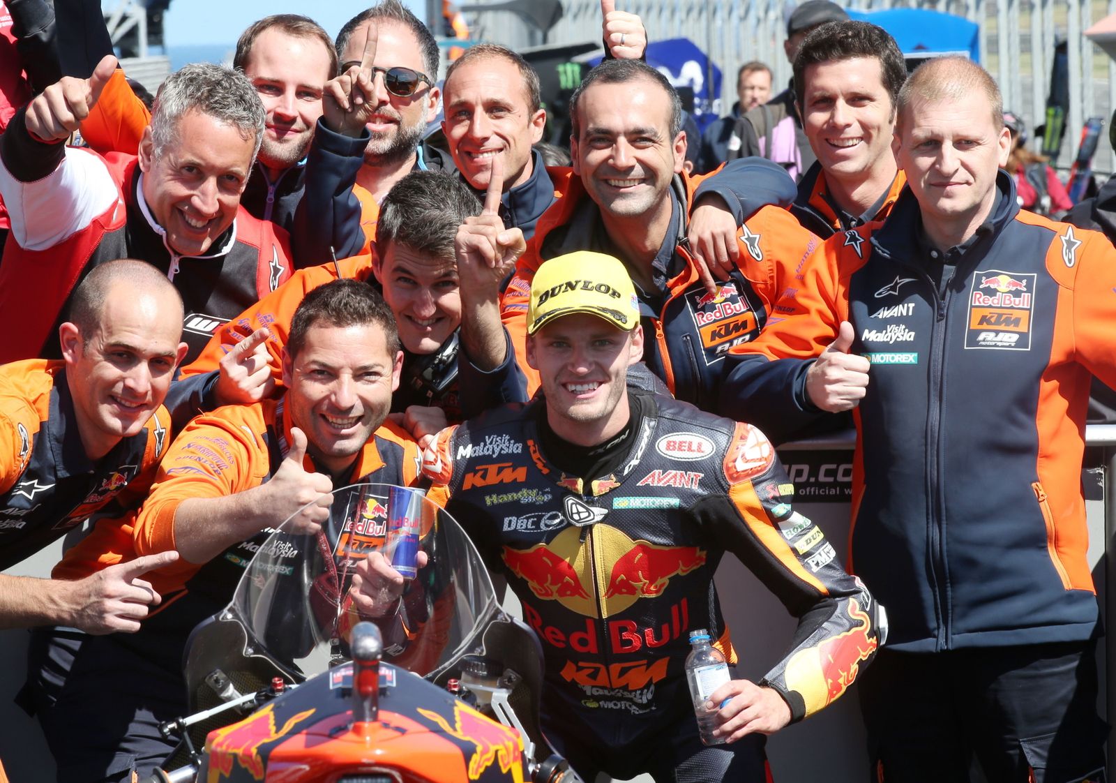El piloto africano Brad Binder posa con su equipo tras lograr la victoria.