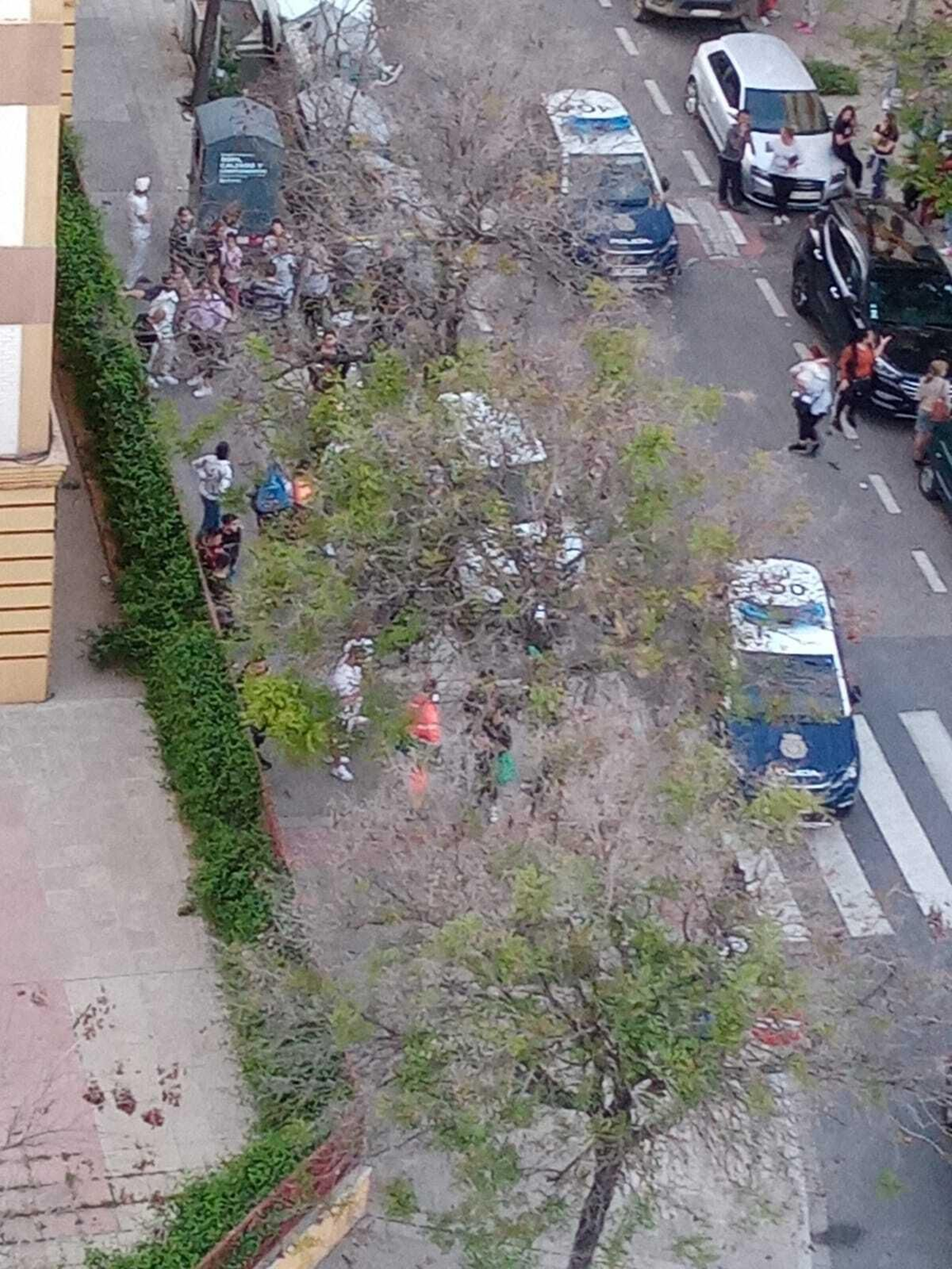 Varias personas observan el trabajo de la Policía, en la calle Fray Serafín Madrid.