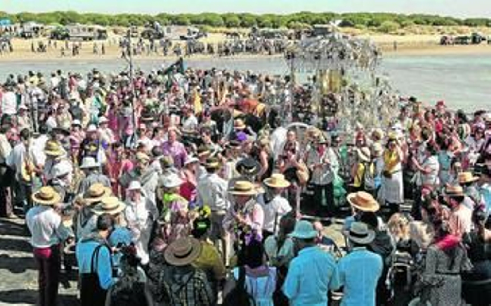 El Simpecado de la hermandad de Sanlúcar, arropado por numerosos peregrinos, en la barcaza cruzando el río.