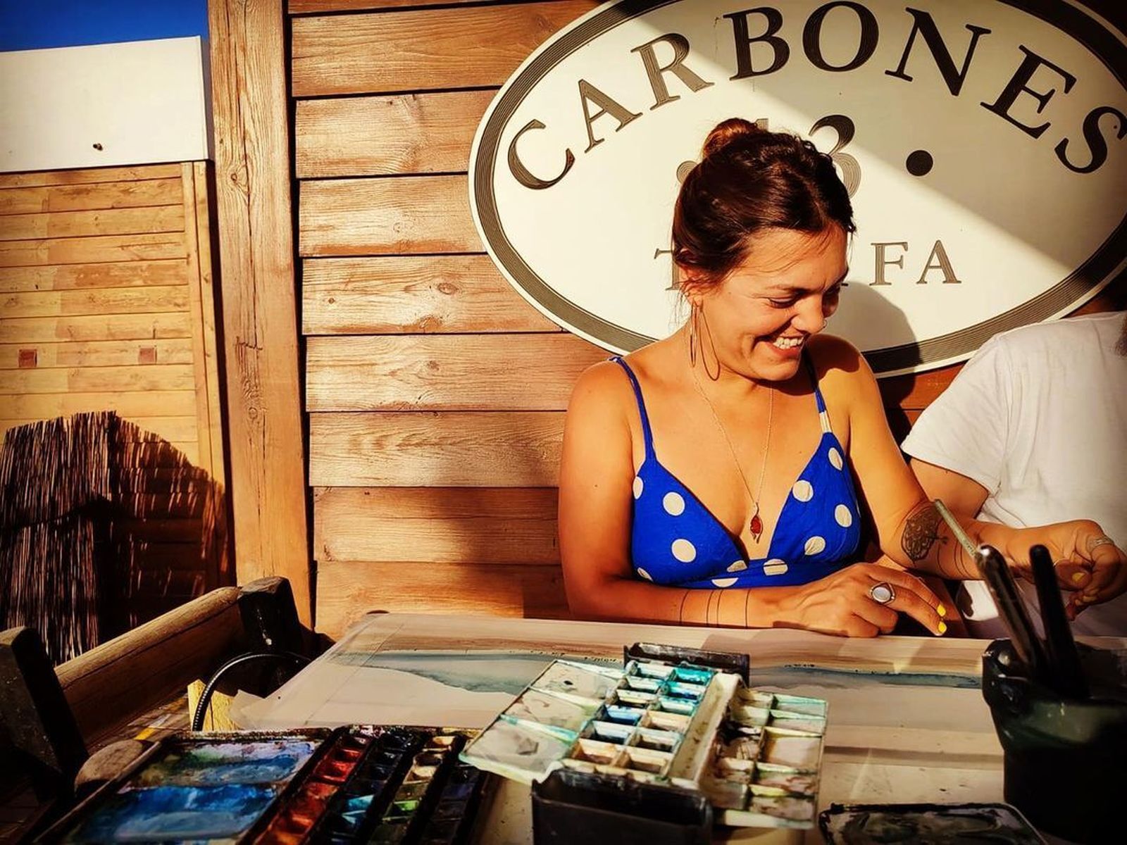 Neila Pascual con sus acuarelas en el chiringuito tarifeño de 'Carbones 13'