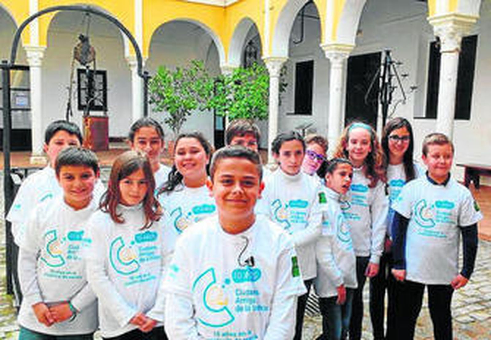 Niños y niñas posan con la camiseta de los diez años del programa CAI.