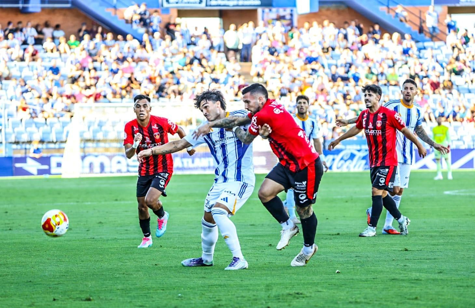 Pugna por un balón entre Néstor Senra y un rival.