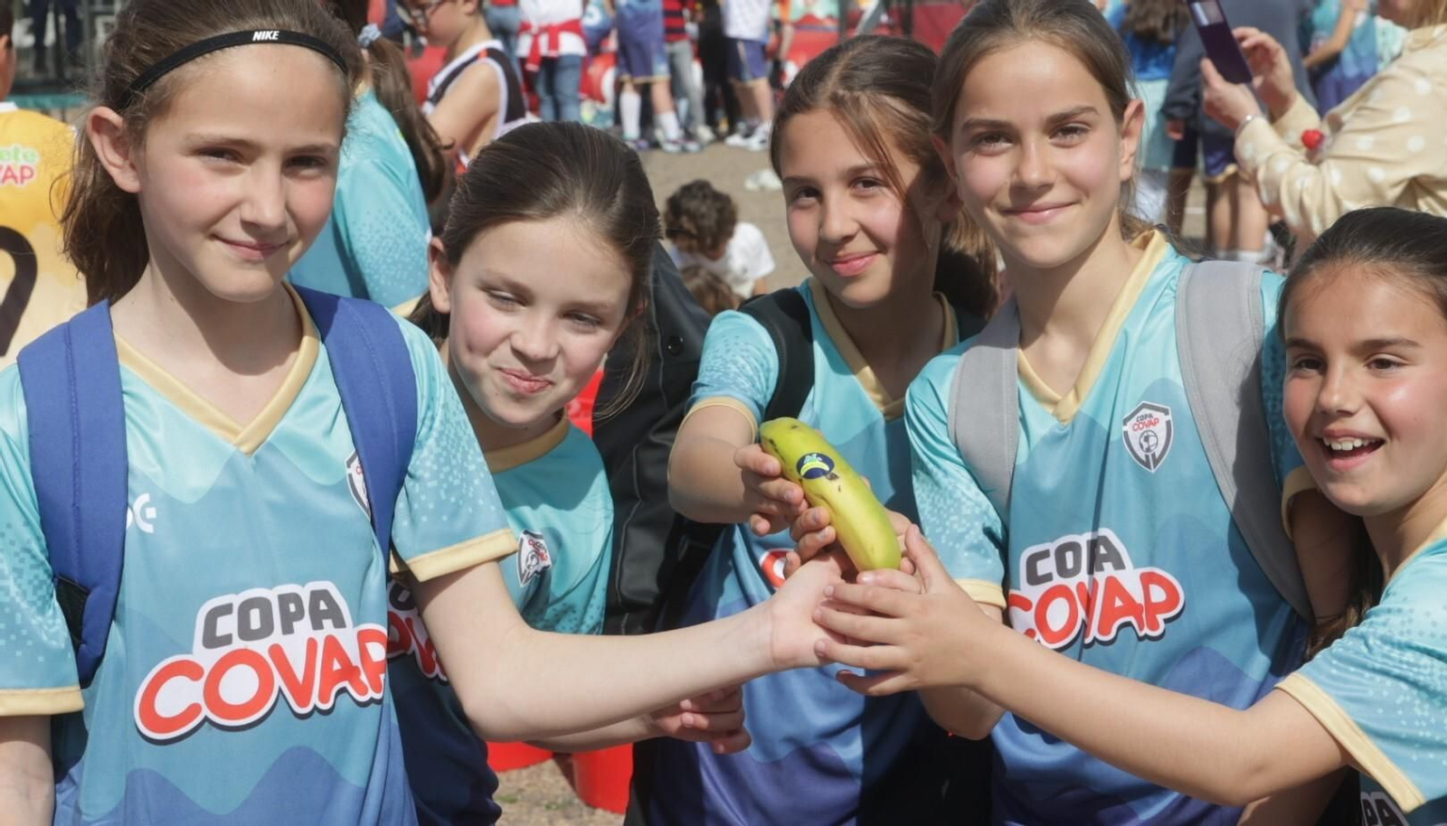 Un grupo de chicas participantes en la Copa COVAP muestran un plátano como ejemplo de merienda saludable.