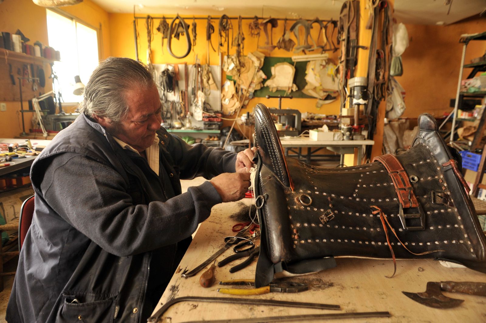 Sebastián Garrido López,  heredero del saber de una saga de guarnicioneros de Villamartín, cose una montura en su taller de esta localidad serrana
