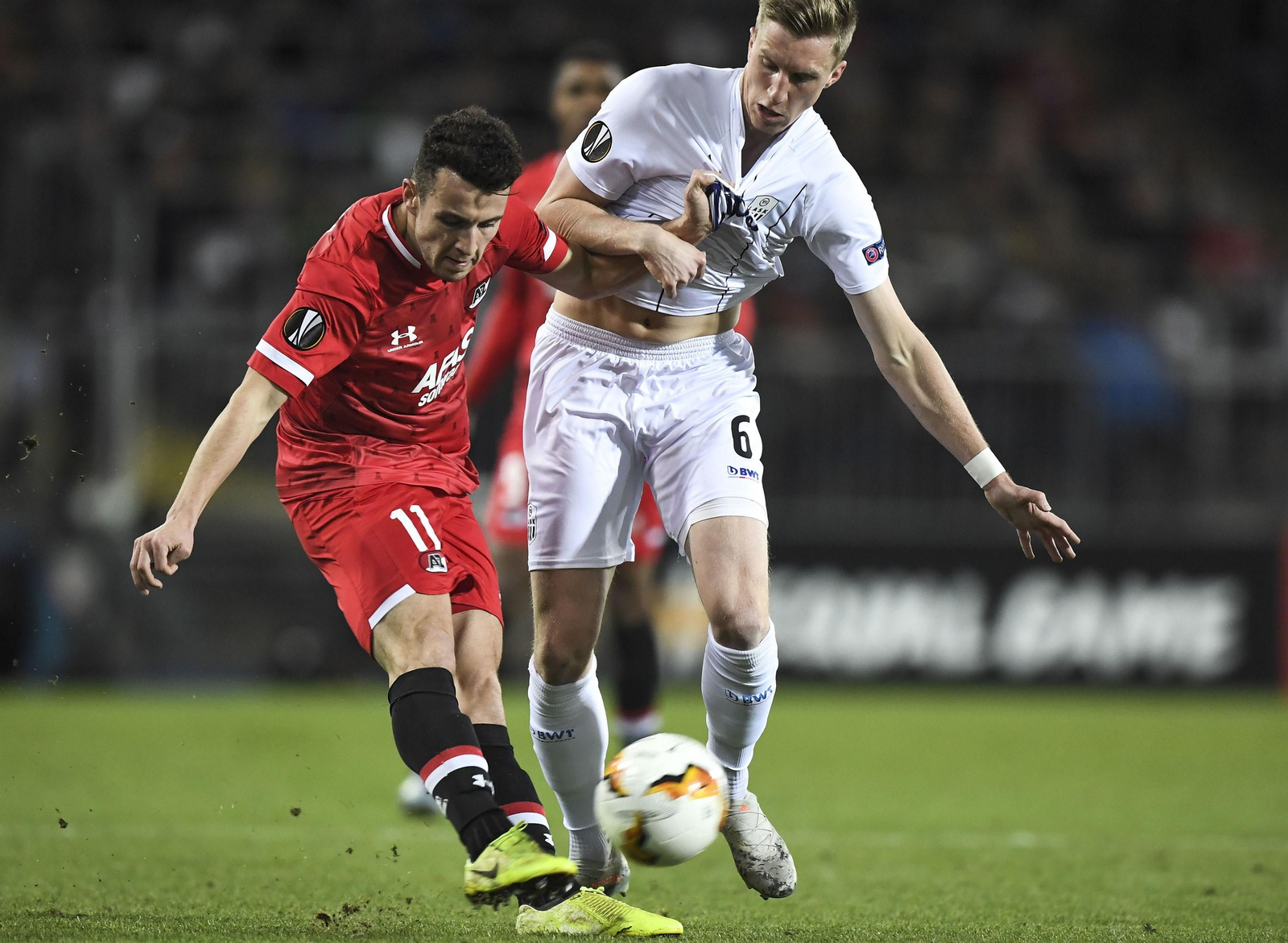 Idrissi saca un centro presionado por un rival en un partido de la Europa League.