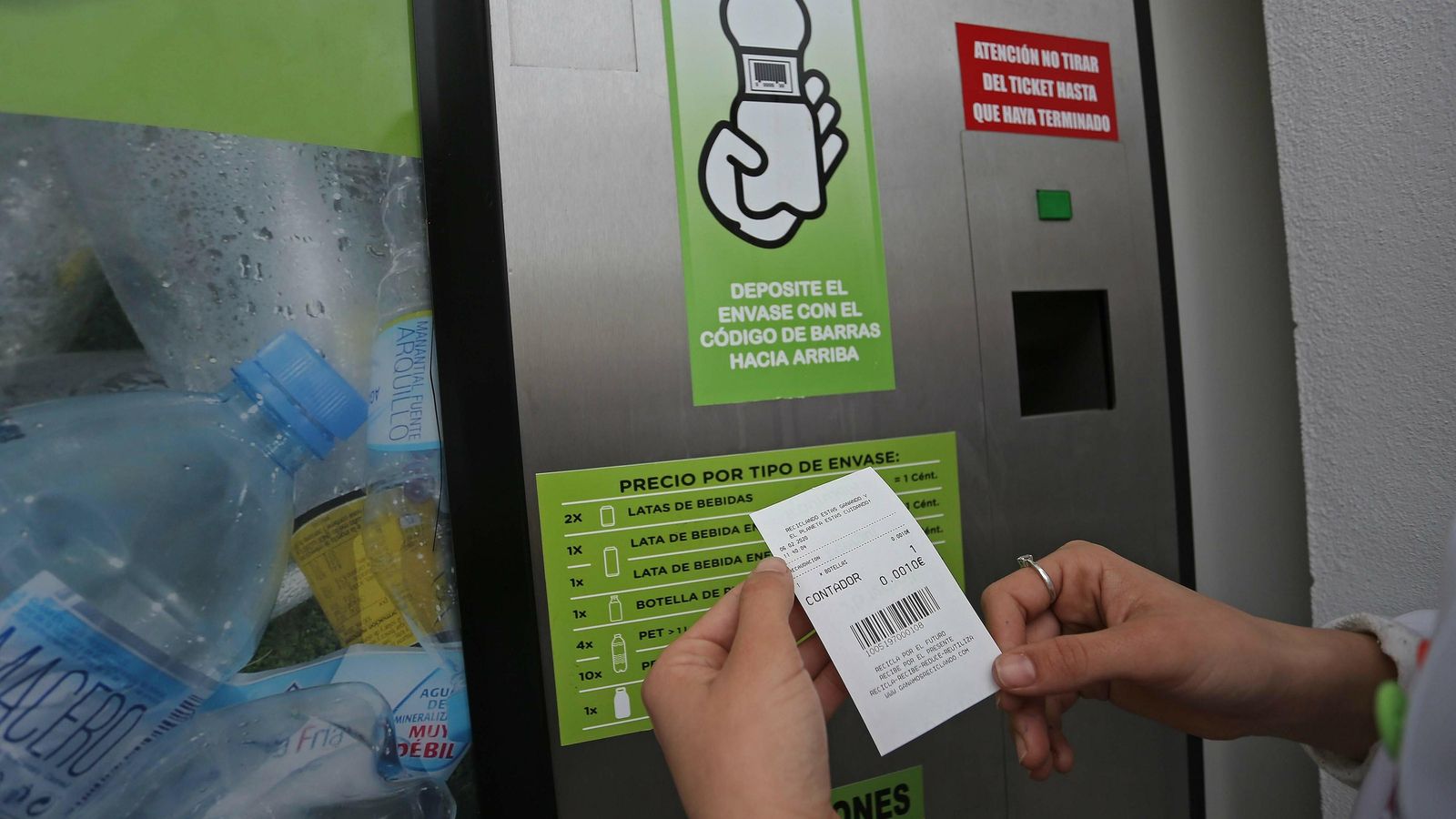 Una persona muestra el tique obtenido tras introducir una botella.
